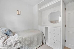 A bedroom with a bed, a bedside table, a wardrobe, and a mirror. - Orchard View Cottage | Escape Ordinary (Derrygonnelly)