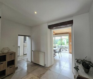 An open-plan living area with a kitchen, dining area, and a view of the outdoors. - House with shared pool - 6 guests (Montignac-Lascaux)