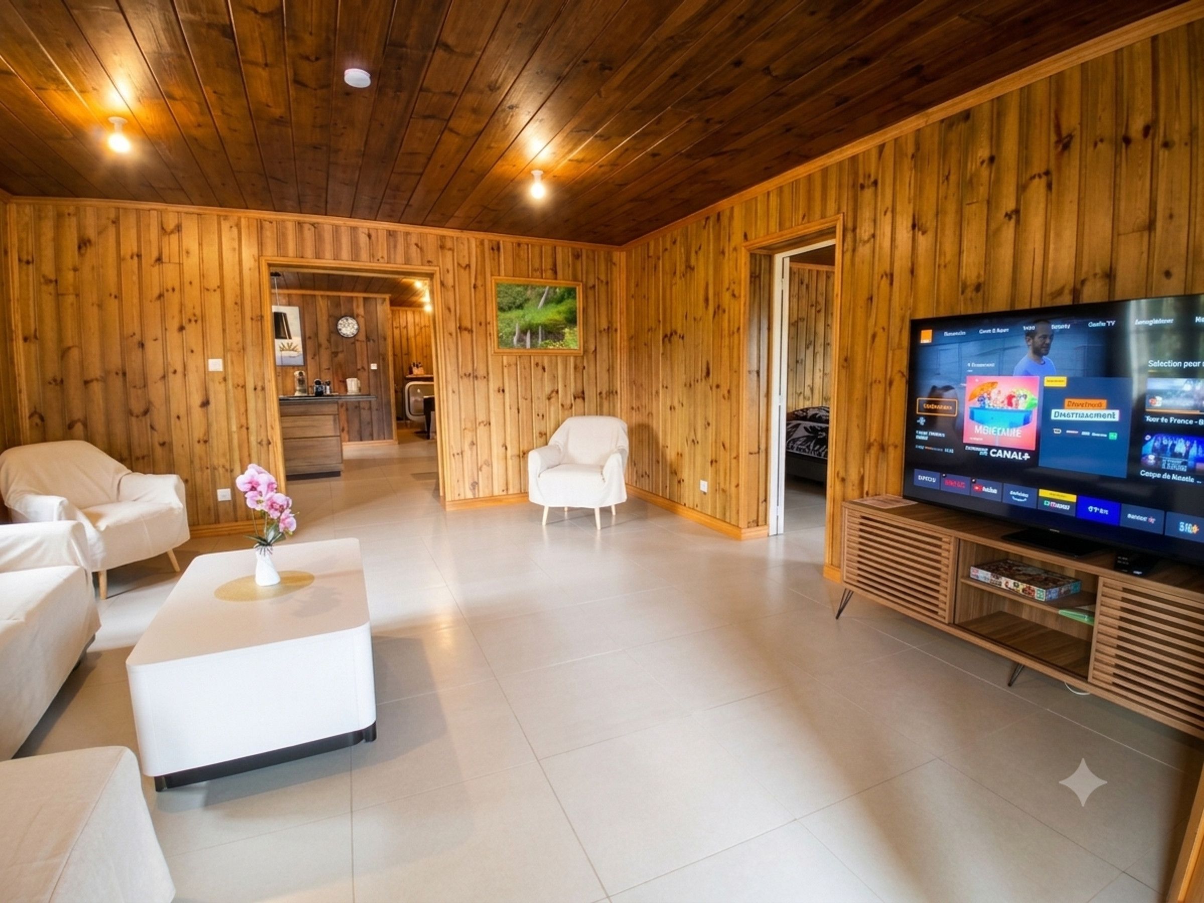 A modern living room with wooden paneling, a flat-screen TV, and a white sofa.