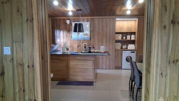 A wooden interior with a kitchen area featuring a sink, countertop, and a washing machine.