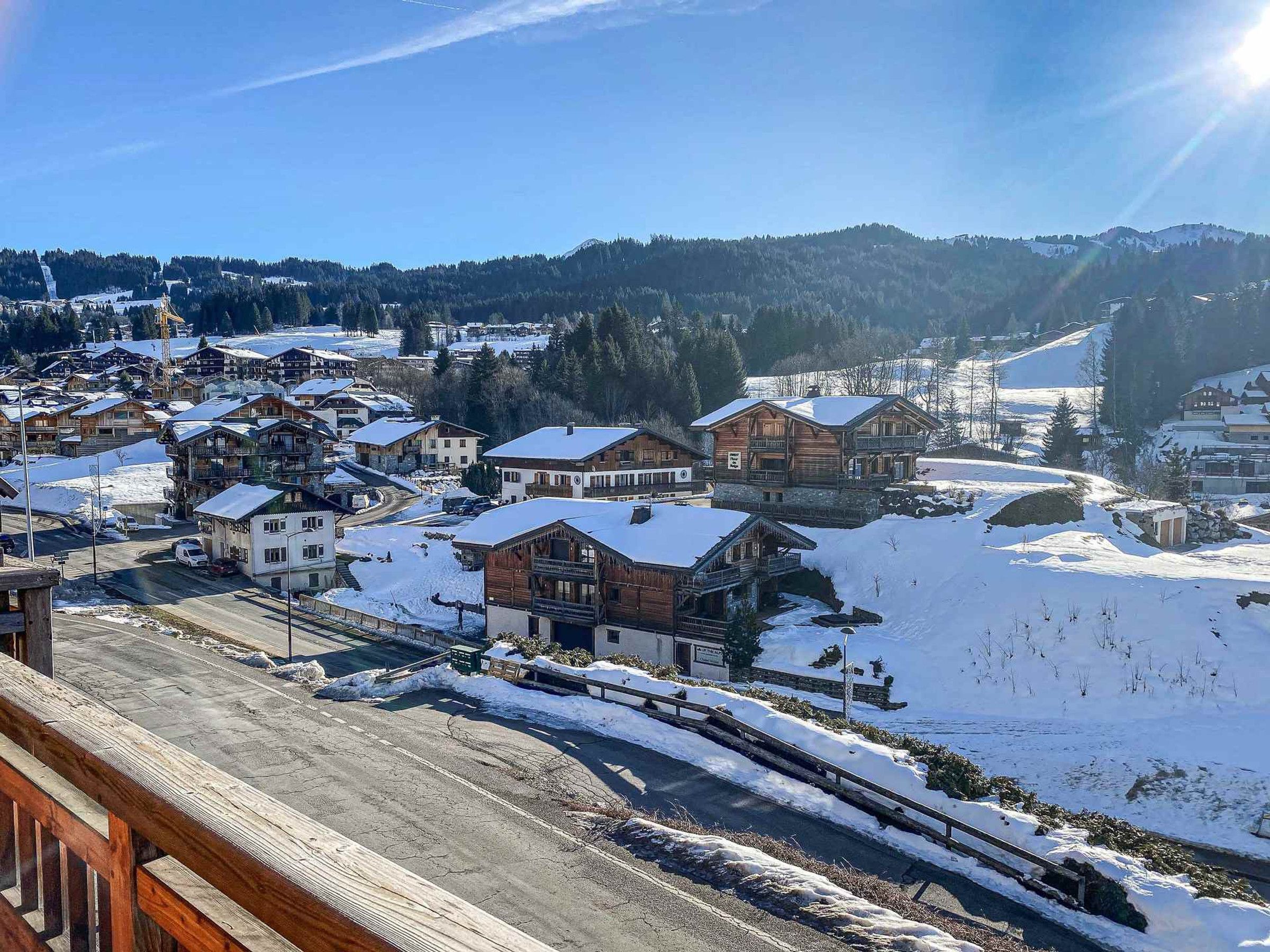 Ein verschneites Dorf mit Holzhäusern und einer Eisenbahnlinie.