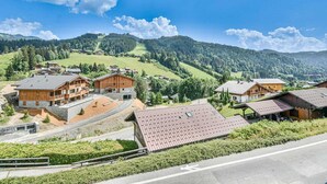 Ein Bergresort mit Holzhäusern, einer asphaltierten Straße und Blick auf die umliegenden Hügel.