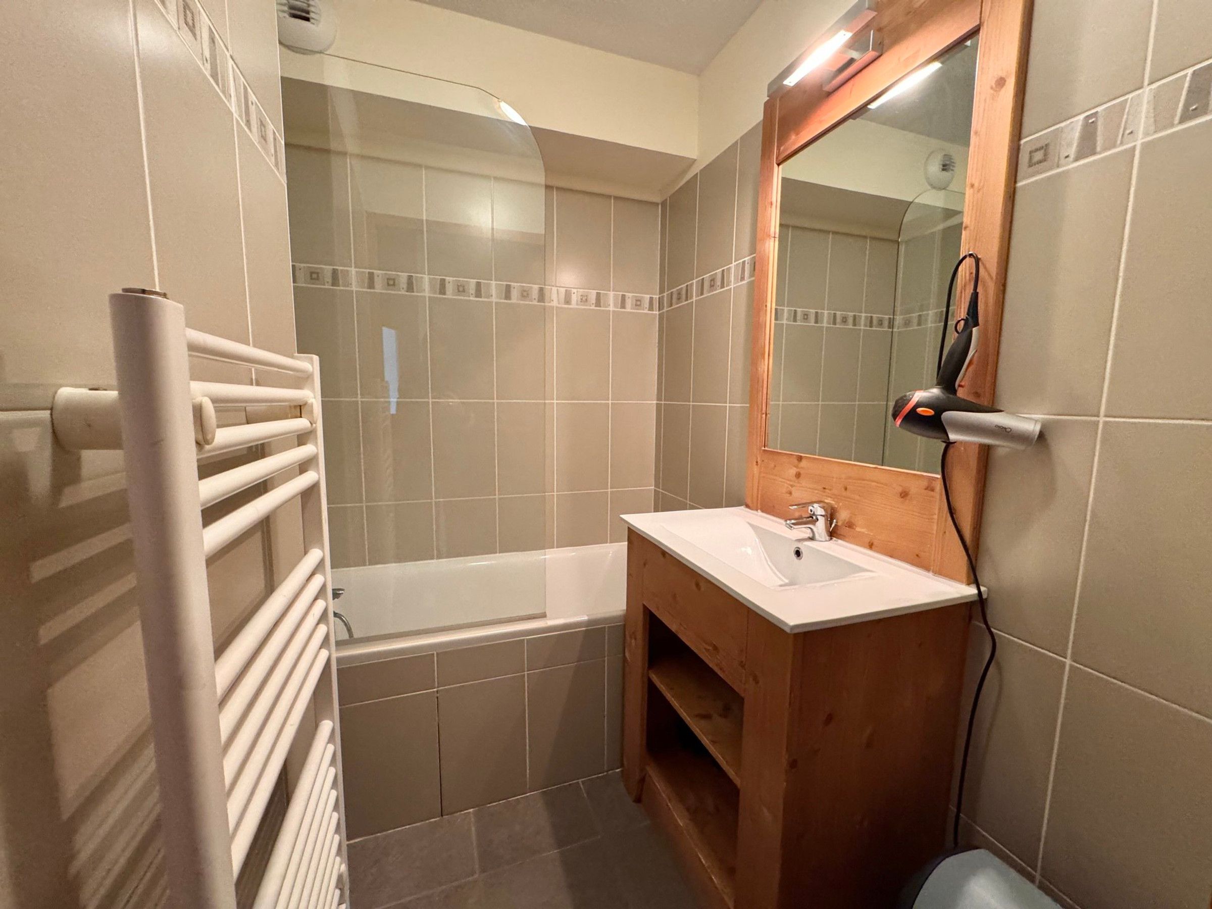 Een badkamer met een bad, een wastafel en een spiegel.
