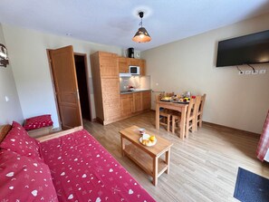 A compact living space with a kitchenette, a dining area, a sofa, and a television. - Apartment pets, mountain view - 4 guests (Vars)
