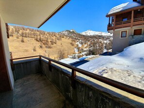 Ein Balkon mit Blick auf eine verschneite Berglandschaft.