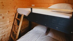 Ein Stockbett in einem Holzraum mit einer Leiter.