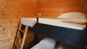 Een stapelbed in een houten kamer met een ladder.