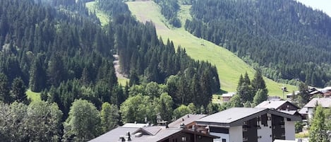 A mountain village with buildings and a ski slope.