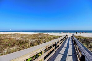 A wooden boardwalk leading to a beach with a clear blue sky. - Windward Pointe 1204 by Liquid Life (Orange Beach)