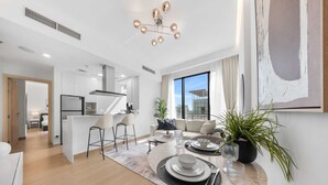 Ein modernes Apartment mit Essbereich, Küche und Wohnzimmer.