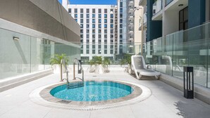 Ein Pool auf dem Dach mit freiem Blick auf einen Hochhaus im Hintergrund.