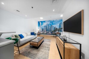 Ein modernes Wohnzimmer mit Stadtbild-Wandgemälde, einer Couch, einem Couchtisch, einem Fernseher und einem Schreibtischbereich.