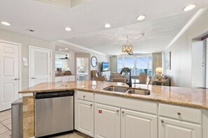 A modern kitchen with granite countertops, stainless steel appliances, and a dishwasher. - San Carlos 1409 by Liquid Life (Gulf Shores)