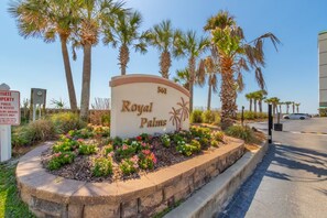 Schild für 'Royal Palms' mit angelegtem Garten und Palmen.