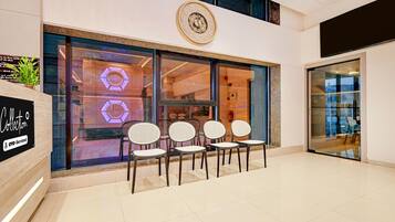 A modern interior with a reception desk, a clock, and seating area.
