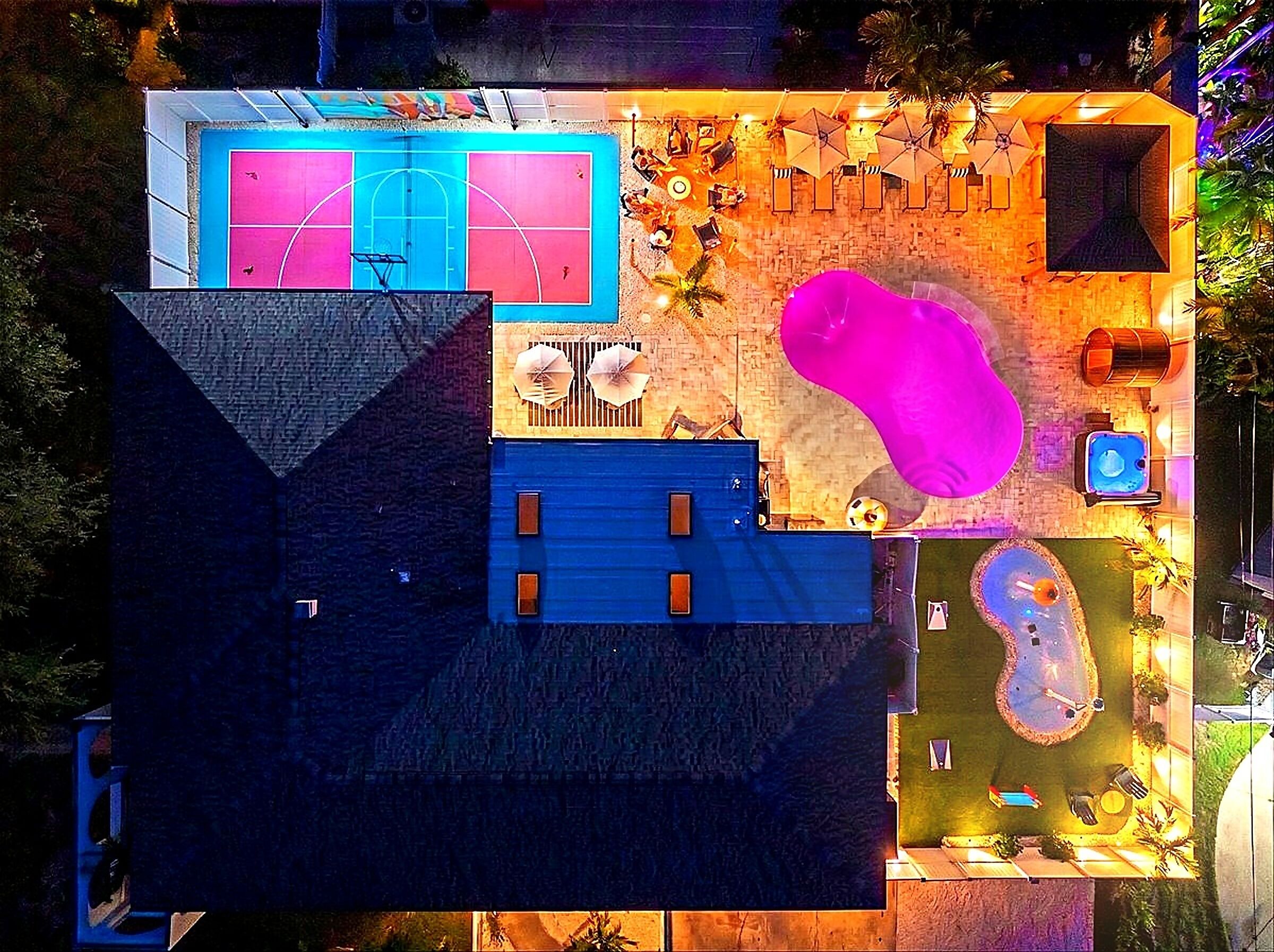 Vista aérea de una propiedad con piscina, sillas de sol y jacuzzi.