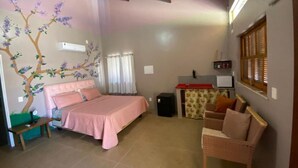 A bedroom with a bed, a chair, a desk, and a wall with a floral mural. - Pousada destino  (Entre rios)