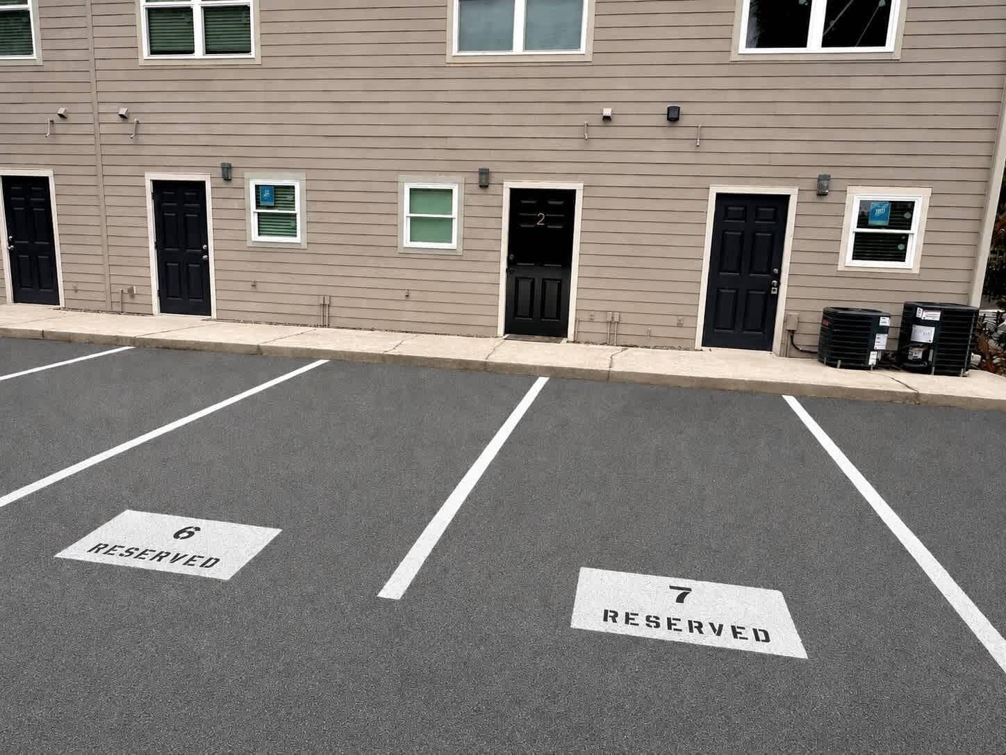 A parking lot with two marked spaces, labeled 6 and 7, reserved for specific purposes.