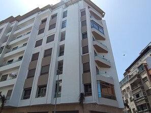 Ein mehrstöckiges Gebäude mit Balkonen, großen Fenstern und einer glatten Fassade.