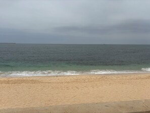 Ein Strand mit sandigem Ufer und ruhiger See.