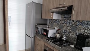 Keittiössä on ruostumattomasta teräksestä valmistettu jääkaappi, mikroaaltouuni, liesi ja kahvinkeitin.