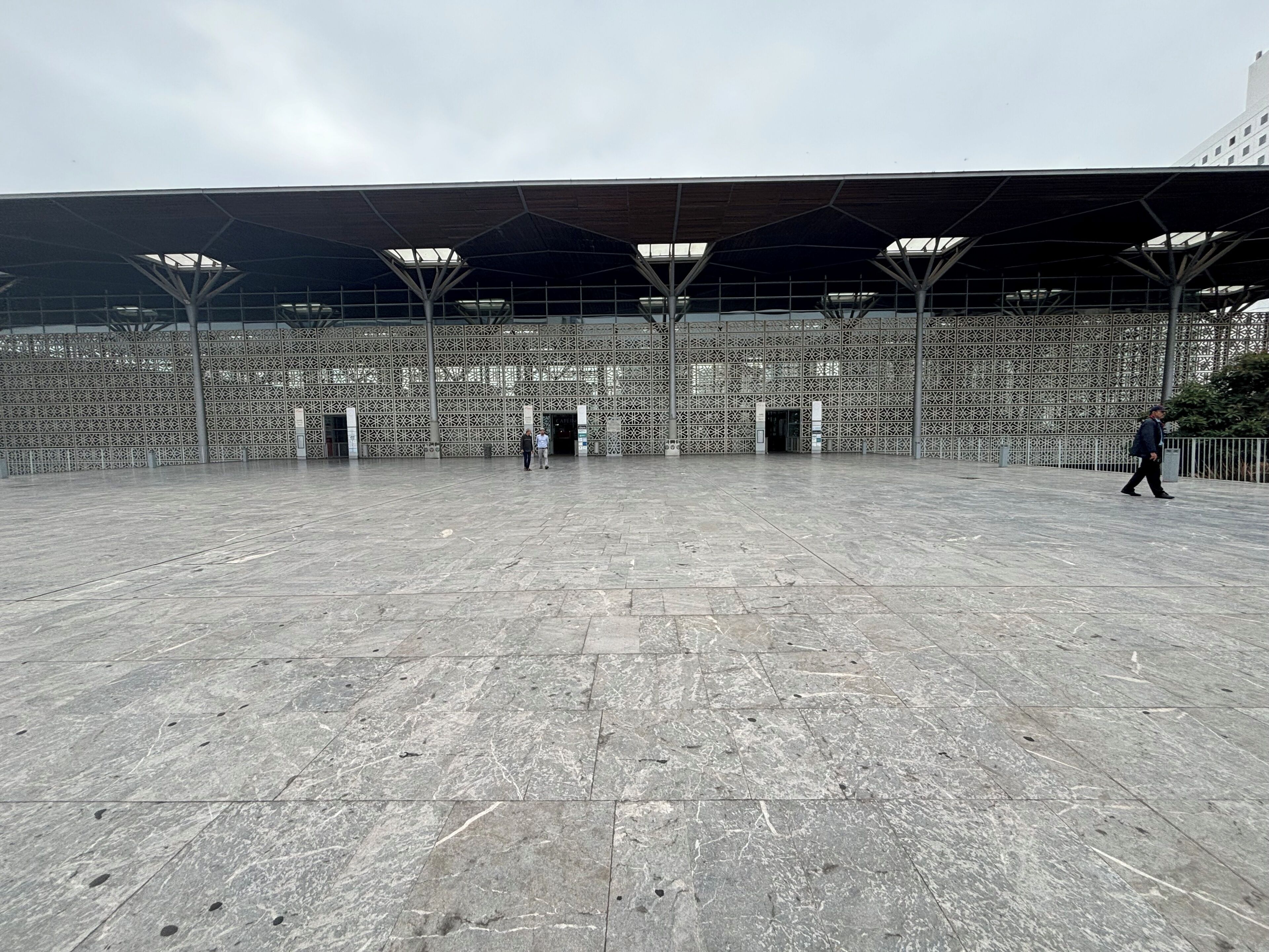 Una arena deportiva interior con un amplio espacio abierto, asientos de diseño estampado y una estructura de techo cubierta.