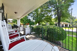 A covered porch with outdoor seating, a potted plant, and a view of a residential street. - Crimson Rose Charmer | Walk to Bryant-Denny Stadium! (Tuscaloosa)