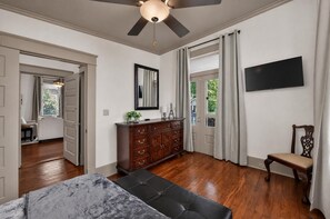 Ein Schlafzimmer mit Bett, Kommode, Fernseher und Stuhl.