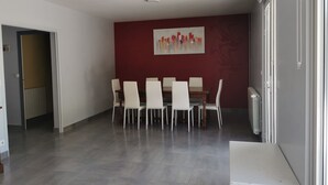 A dining area with a red accent wall, a white ceiling, and a tiled floor. - House in the heart of the village (Chevanceaux)