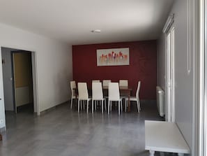 A dining area with a red accent wall, a white ceiling, and a tiled floor. - House in the heart of the village (Chevanceaux)