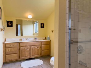 A bathroom with a wooden vanity, a white sink, a mirror, and a shower area. - Mare Vista (TOT # 2194): 2  BR, 2  BA House in The Sea Ranch, Sleeps 4 (The Sea Ranch)