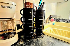 A kitchen counter with a coffee maker, a stack of espresso cups, and a yellow sink. - 4-Min Walk to Bio Bay & Beach • Beach Day Ready (Esperanza)
