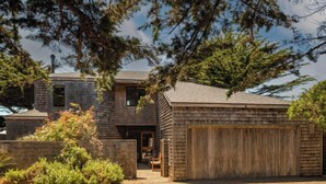 A two-story house with a garage, surrounded by trees and shrubs. - Autumn Mist TOT #2141: 2  BR, 2.5  BA House in The Sea Ranch, Sleeps 4 (The Sea Ranch)
