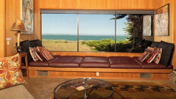 A room with a large window, a leather sofa, a glass coffee table, and a lamp. - Autumn Mist TOT #2141: 2  BR, 2.5  BA House in The Sea Ranch, Sleeps 4 (The Sea Ranch)
