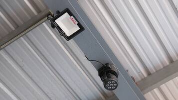 A ceiling with a mounted light fixture and a control panel.