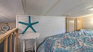 A bedroom with a bed, a starfish decoration, a clock, and wooden furniture.