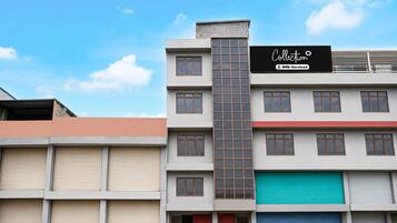 A multi-story building with a sign indicating it is serviced by OYO.