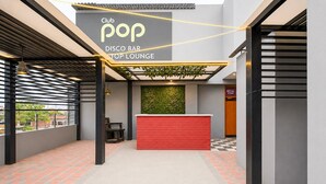 Ein Club, Pop-Disco-Bar-Lounge mit einem roten Empfangstresen, schwarz-wei ß kariertem Boden und einer Wandgestaltung in Grün.