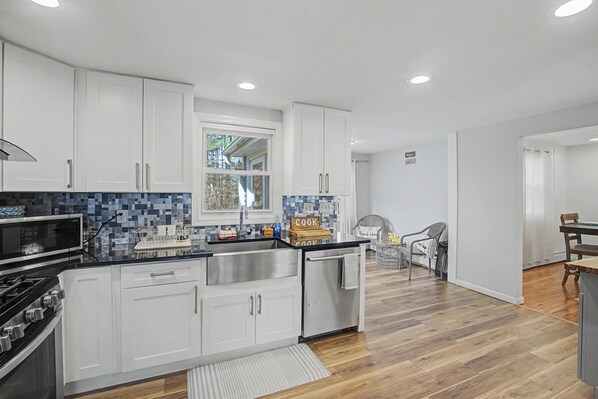 A modern kitchen with white cabinets, a stainless steel sink, and a microwave. - 3 Mi to Talcott Mtn! Family Home w/ Yard & Grill (Bloomfield)