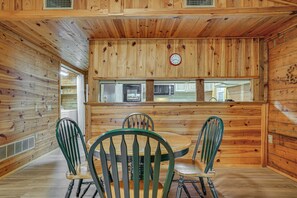 Ein Holzinterieur mit einem Essbereich, der einen runden Tisch und vier Stühle zeigt.