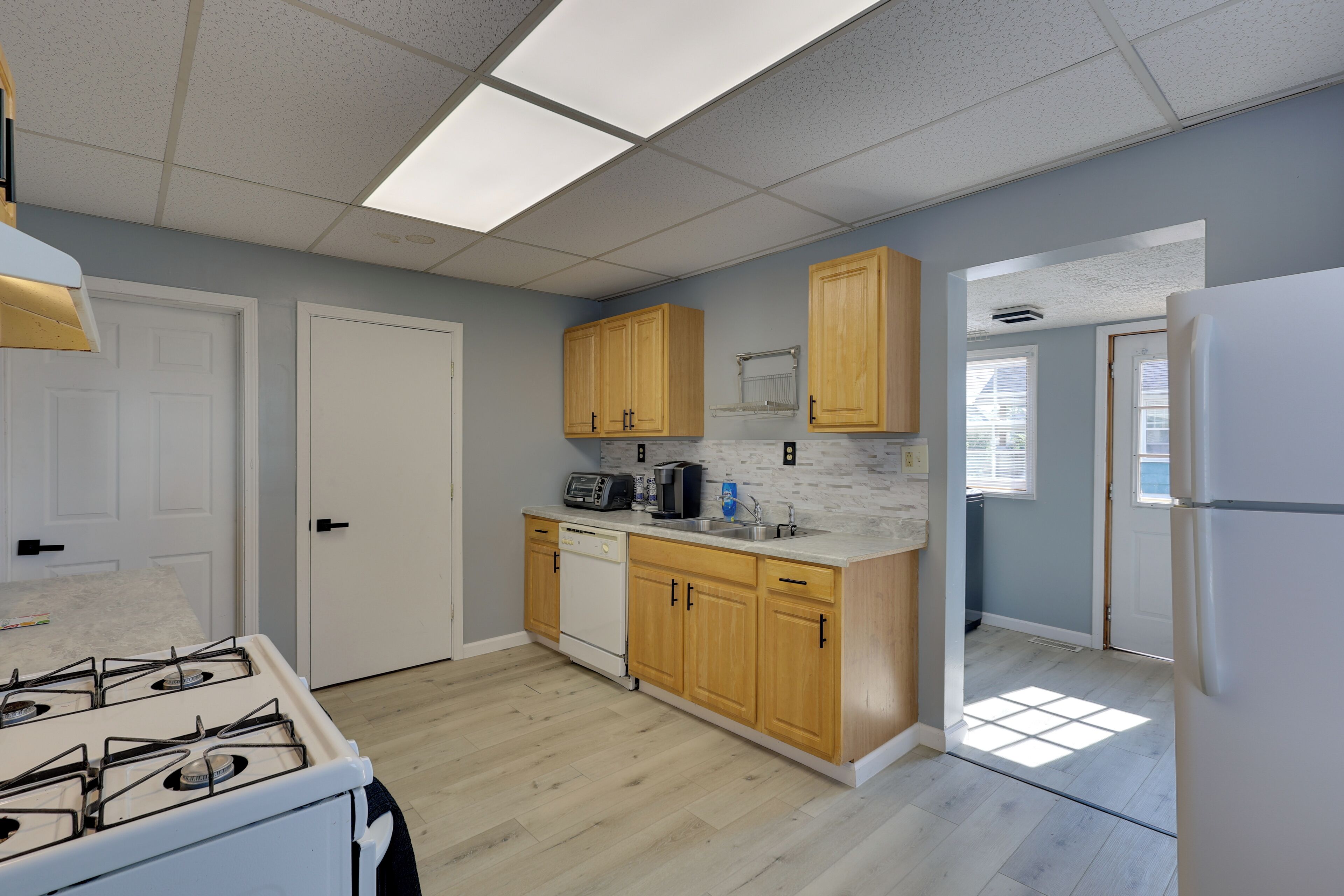 A kitchen with wooden cabinets, a white stove, and a countertop with a coffee maker.