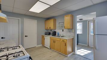 A kitchen with wooden cabinets, a white stove, and a countertop with a coffee maker.