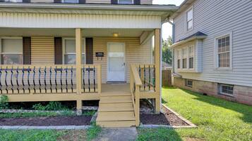 A two-story building with a covered porch and a small front yard.