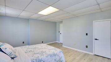 A bedroom with a bed, a door, and a light switch on the wall.