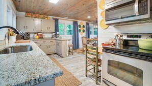 A kitchen with granite countertops, white cabinets, a microwave, and a stove. - < 1/2 Mi to Lake Burton! Forest-view Sanctuary (Clarkesville)