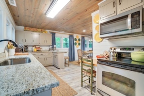 A kitchen with granite countertops, white cabinets, a microwave, and a stove. - < 1/2 Mi to Lake Burton! Forest-view Sanctuary (Clarkesville)