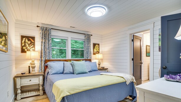 A bedroom with a bed, two bedside tables, a nightstand, a window with curtains, and a door. - < 1/2 Mi to Lake Burton! Forest-view Sanctuary (Clarkesville)