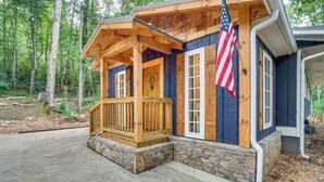 A wooden cabin with a stone foundation, a porch, and an American flag. - < 1/2 Mi to Lake Burton! Forest-view Sanctuary (Clarkesville)