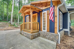 A wooden cabin with a stone foundation, a porch, and an American flag. - < 1/2 Mi to Lake Burton! Forest-view Sanctuary (Clarkesville)
