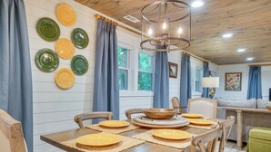 A dining area with a wooden table, chairs, and a central bowl. - < 1/2 Mi to Lake Burton! Forest-view Sanctuary (Clarkesville)
